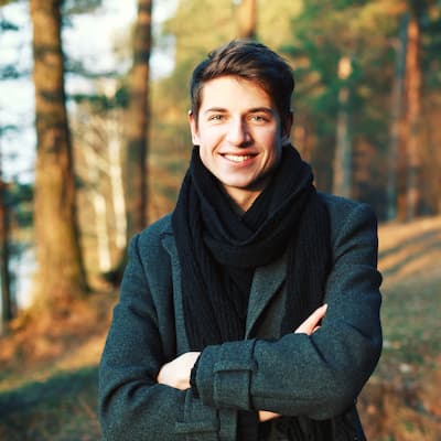 smiling-young-man-with-crossed-arms-outdoors(1)